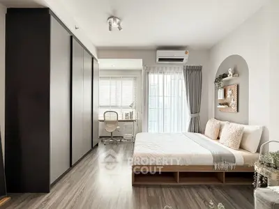 Modern bedroom with stylish decor and natural light, featuring a cozy workspace and elegant furnishings.