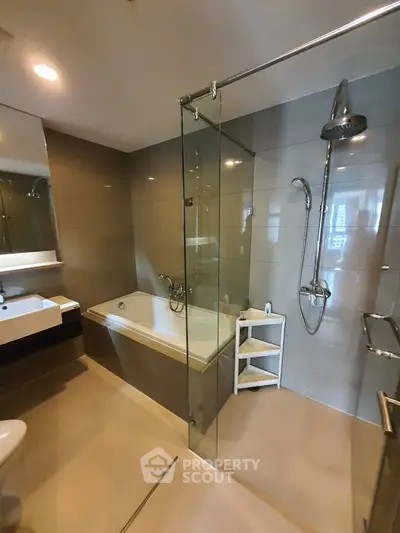 Modern bathroom with glass shower and bathtub in luxury apartment
