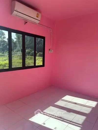 Vibrant pink room with large window and air conditioning, perfect for a cozy living space.