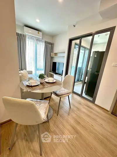 Modern dining area with elegant table setting and natural light in a cozy apartment.