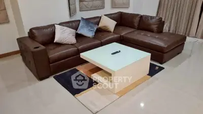 Modern living room with stylish brown leather sectional sofa and sleek coffee table on a chic rug.
