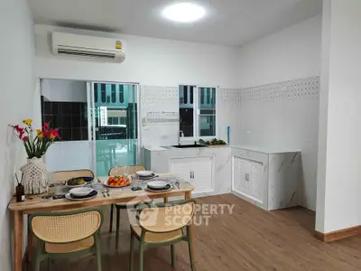 Modern kitchen with dining area, featuring sleek cabinetry and stylish decor, perfect for family gatherings.
