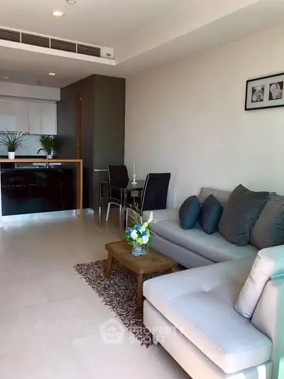 Modern living room with cozy sofa and open kitchen layout, perfect for stylish urban living.