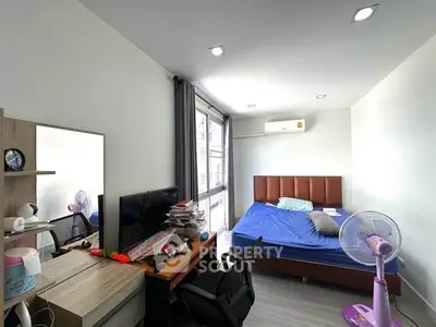 Modern bedroom with desk and large window in a stylish apartment.