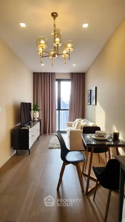 Modern living room with elegant chandelier and cozy dining area, featuring a large window with city view.