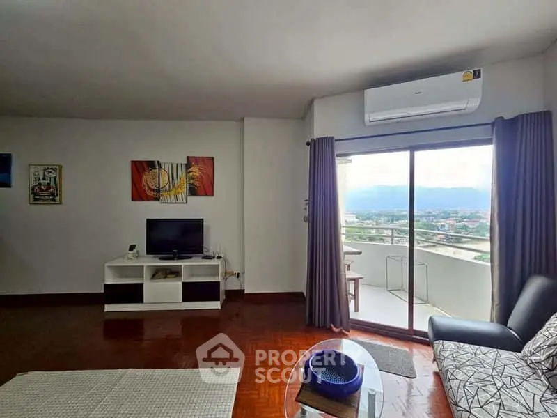 Spacious living room with balcony and scenic view, featuring modern decor and air conditioning.