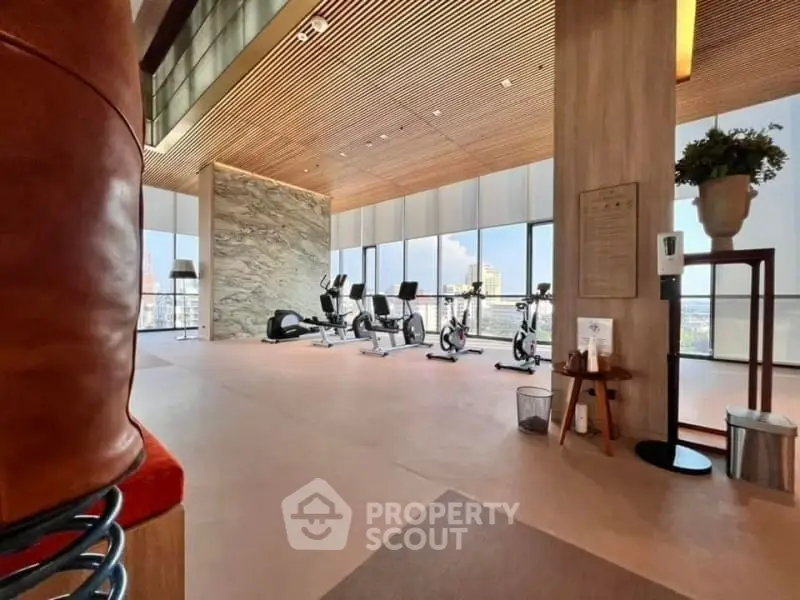 Luxurious high-rise gym with panoramic city views and modern fitness equipment.