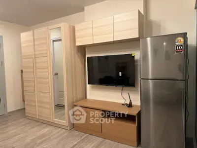 Modern living room with sleek wooden furniture and stainless steel fridge