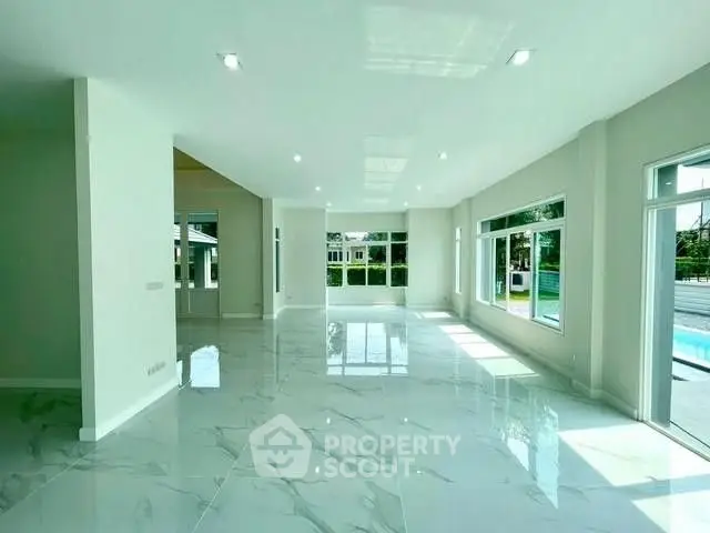 Spacious modern living room with large windows and glossy marble floors