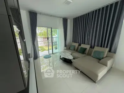 Modern living room with sleek design and large windows opening to a garden view.