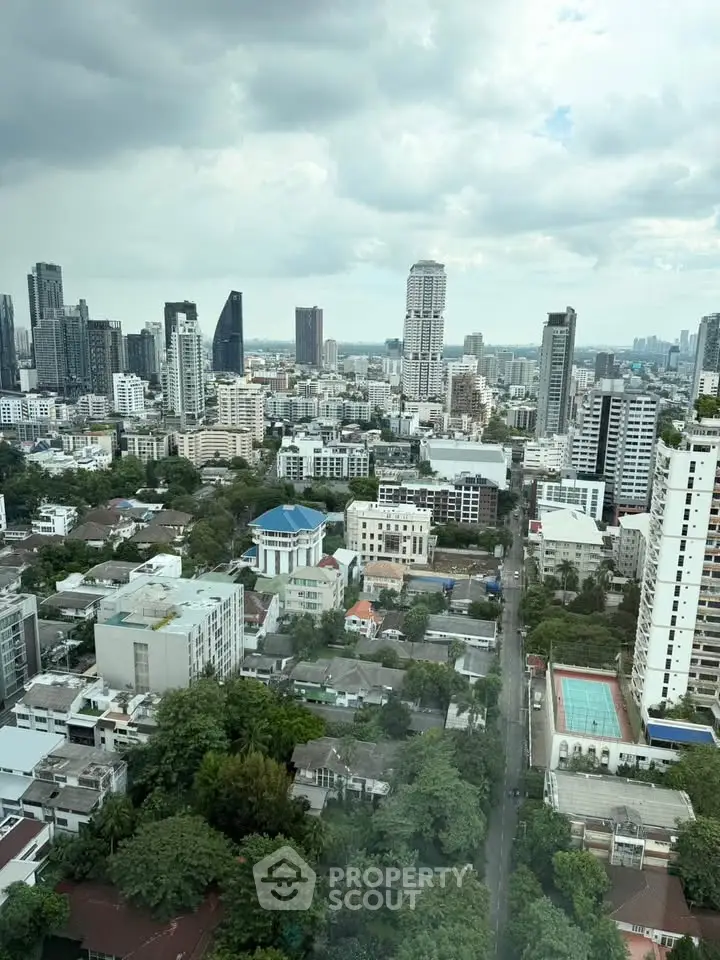 Stunning cityscape view from high-rise building showcasing urban skyline and lush greenery.