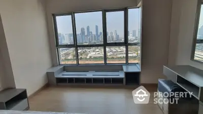 Spacious living room with large windows offering a panoramic city view, modern design, and ample natural light.