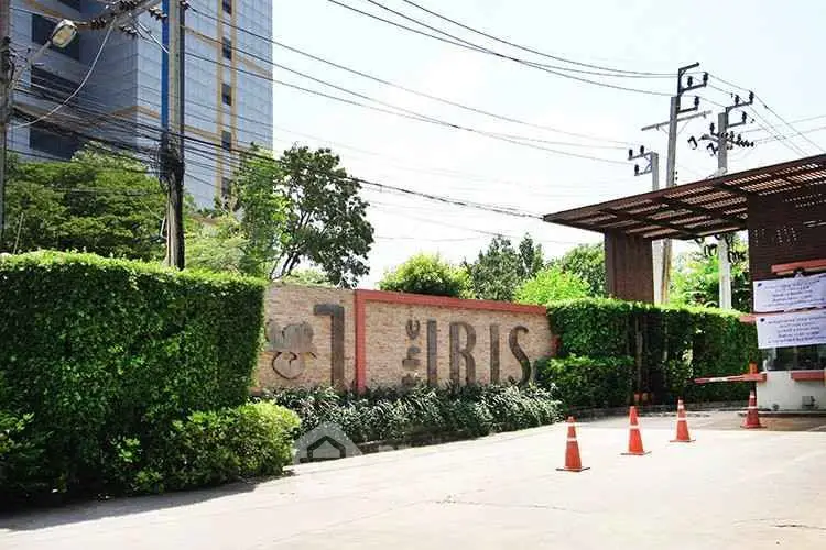 Modern building entrance with lush greenery and security barriers