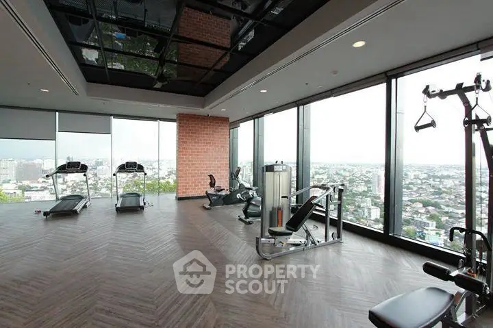 Luxurious high-rise gym with panoramic city views and modern fitness equipment.