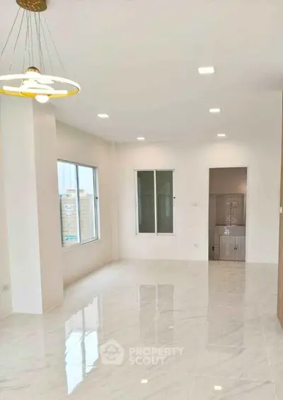 Spacious modern living room with glossy tile flooring and elegant lighting