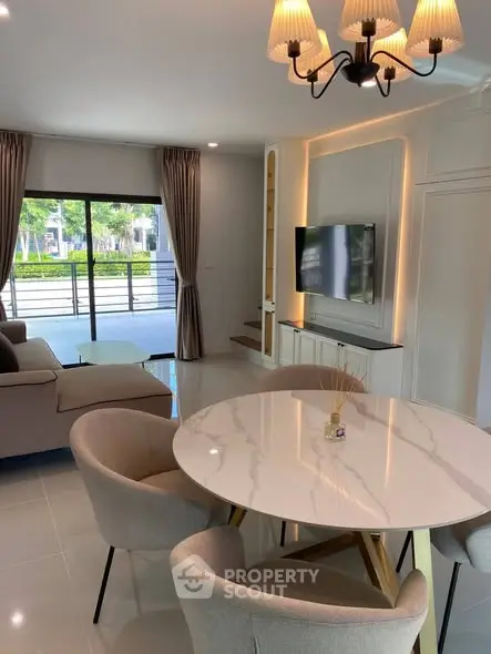 Modern living room with elegant dining area and large windows for natural light.