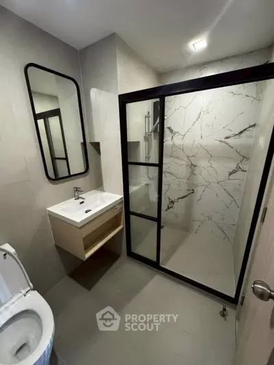 Modern bathroom with sleek shower and stylish vanity in contemporary home.