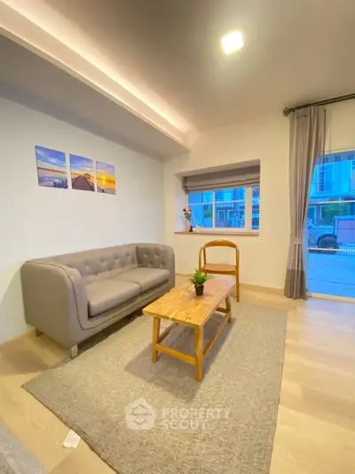 Charming living room with modern decor and natural light, featuring a cozy sofa and stylish wooden coffee table.