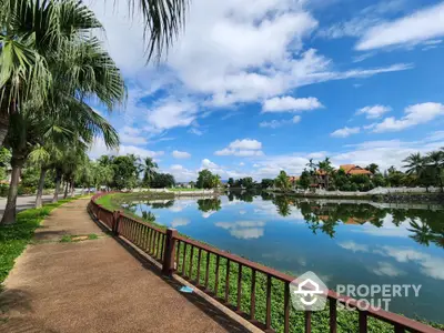 Scenic view of a serene lake with palm trees and clear blue sky, perfect for tranquil living.