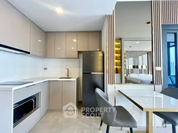 Modern kitchen with sleek cabinetry and dining area in a stylish apartment