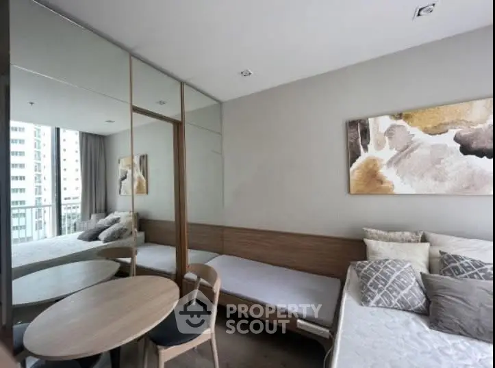 Modern bedroom with stylish decor and large windows offering city views