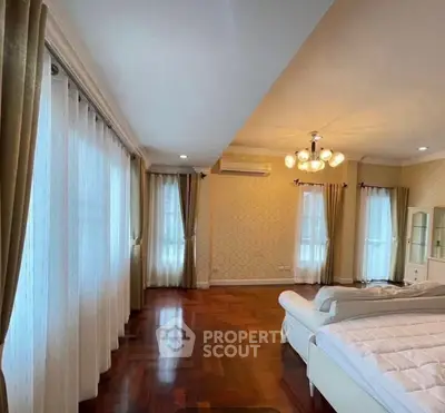 Spacious bedroom with elegant decor and large windows for natural light.