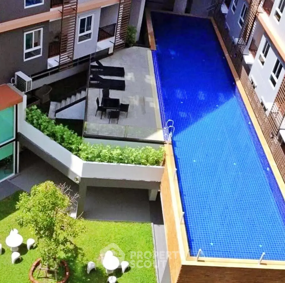 Modern apartment complex with a stunning rooftop pool and lush garden area.