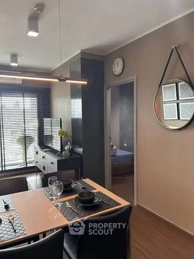 Modern dining area with stylish decor and view into cozy bedroom, perfect for urban living.