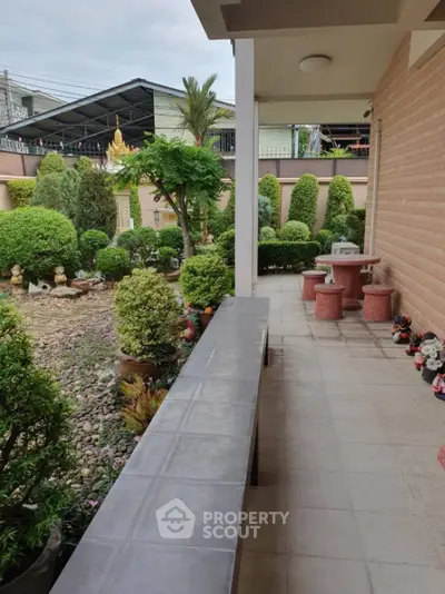 Charming garden view from a spacious patio with seating area, perfect for relaxation and outdoor gatherings.