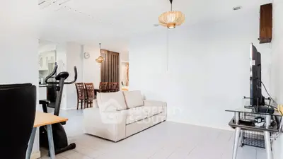 Spacious living room with modern decor and exercise equipment, perfect for relaxation and fitness.