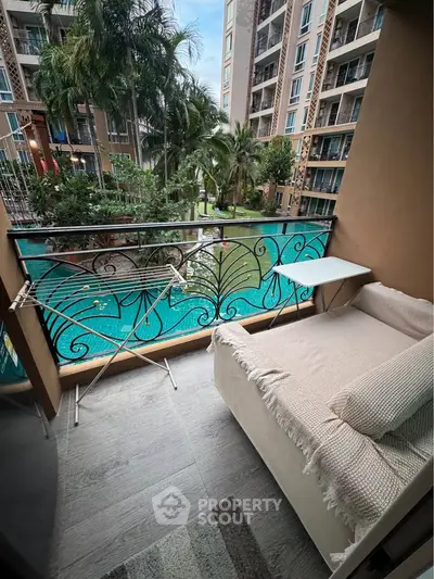 Charming balcony with pool view in modern apartment complex, perfect for relaxation and enjoying outdoor scenery.