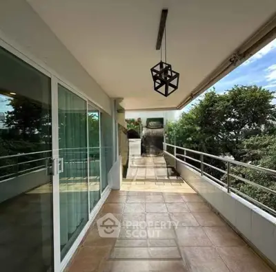 Spacious balcony with modern lighting and lush greenery view