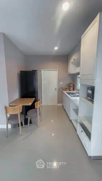 Modern kitchen with sleek cabinetry and dining area in a stylish apartment.