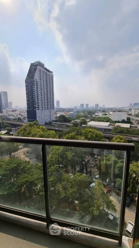 Stunning cityscape view from a high-rise balcony with lush greenery and modern architecture.