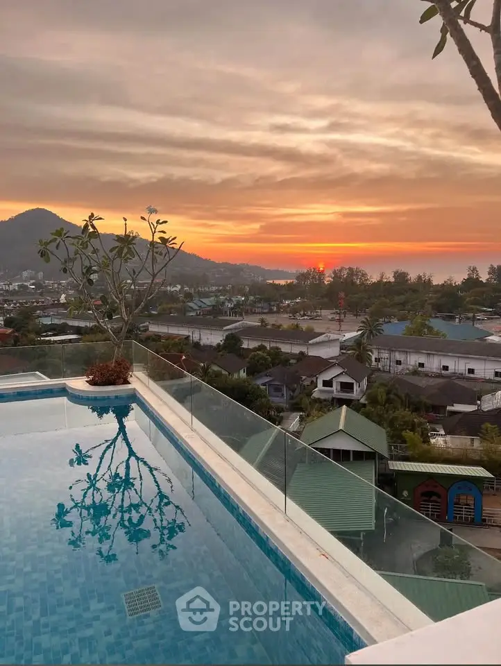 Stunning rooftop pool with breathtaking sunset view over the cityscape and mountains.
