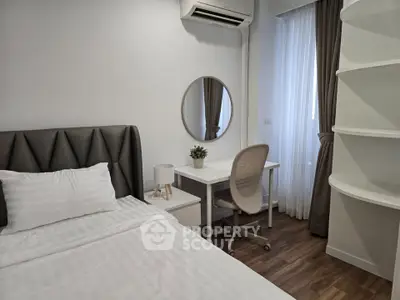 Modern bedroom with stylish decor and workspace, featuring a cozy bed and elegant furnishings.
