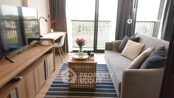 Modern living room with stylish decor and balcony view, featuring a cozy sofa and entertainment setup.