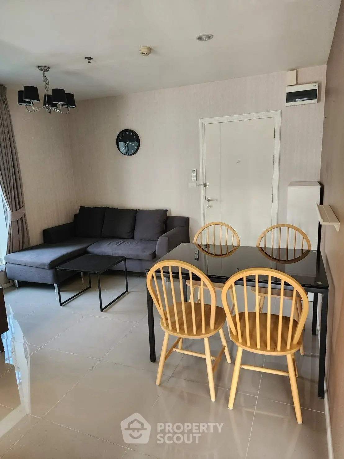 Modern living room with sleek furniture and dining area in open layout apartment.