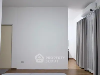 Minimalist bedroom with air conditioning and floor-to-ceiling curtains