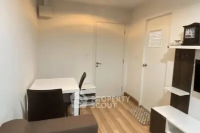 Cozy study area with modern furniture and wooden flooring in a compact apartment.