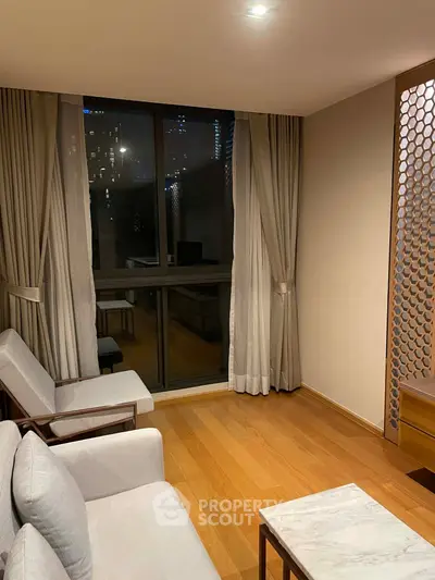 Elegant living room with wooden flooring and city view through large window.