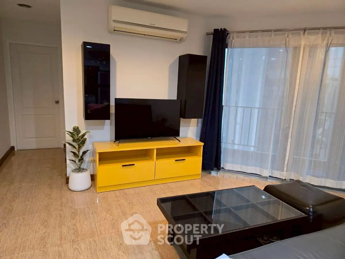 Modern living room with bright yellow TV stand and sleek black furniture