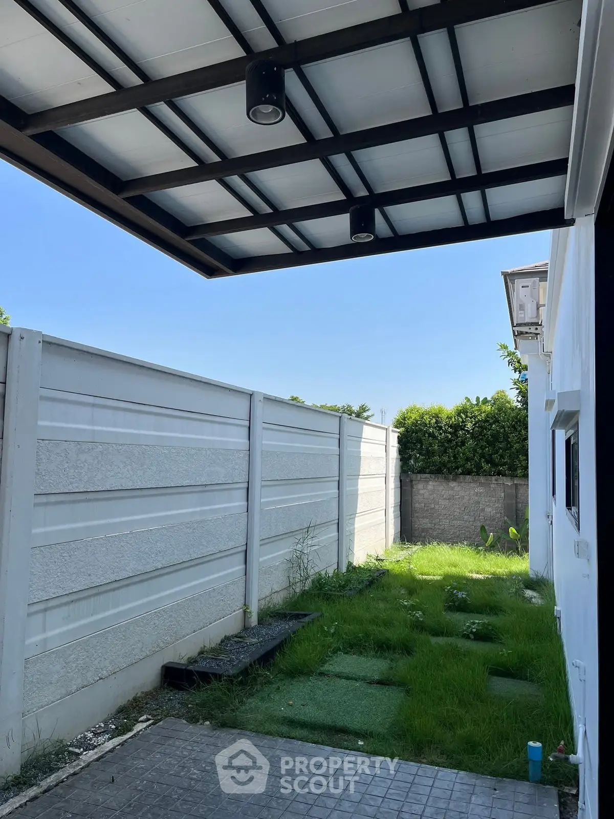 Charming backyard with lush greenery and modern fence, perfect for outdoor relaxation.