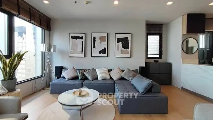 Modern living room with stylish decor and large windows offering city views.