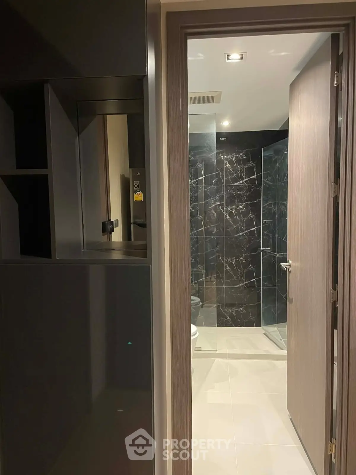 Modern bathroom with sleek design and glass shower enclosure in luxury apartment.