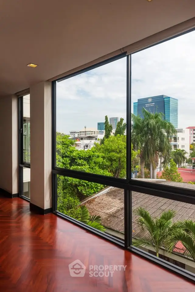 Spacious corner unit with floor-to-ceiling windows offering a stunning city view and lush greenery.