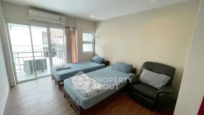 Spacious bedroom with twin beds and balcony access in modern apartment