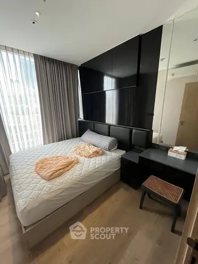 Modern bedroom with sleek design and large window for natural light.