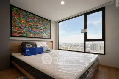Modern bedroom with large window offering stunning city view, featuring a comfortable bed and vibrant wall art.