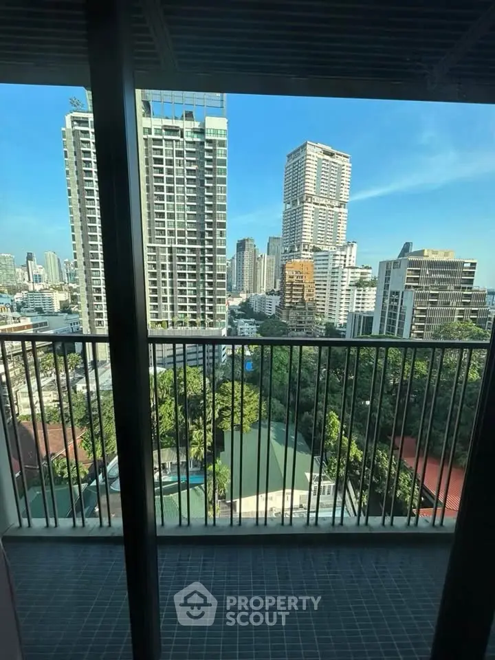 Stunning cityscape view from a high-rise balcony overlooking lush greenery and modern skyscrapers.